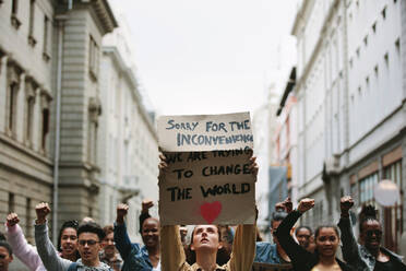 Eine Gruppe von Demonstranten, die gegen die globale Erwärmung protestieren, marschiert auf die Straße. - JLPSF11565