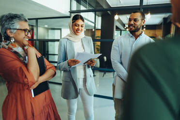 Glückliche Unternehmer, die während einer Geschäftsbesprechung in einem modernen Büro fröhlich lächeln. Gruppe erfolgreicher Geschäftsleute, die in einem multikulturellen Arbeitsumfeld als Team zusammenarbeiten. - JLPSF11820