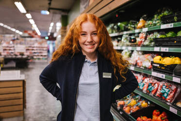 Porträt einer jungen Supermarktangestellten, einer Studentin bei einem Ferienjob in einem Lebensmittelgeschäft. - JLPSF11881