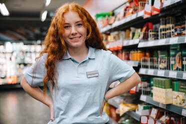 Woman working in a supermarket. Female student on holiday job at modern grocery store. - JLPSF11937