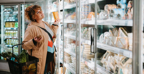 Frau kauft Lebensmittel in einem Supermarkt ein. Weiblicher Kunde kauft im Supermarkt ein. - JLPSF11958