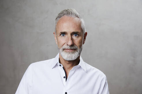 Älterer Mann mit grauem Haar und Bart vor grauem Hintergrund - FMKF07744