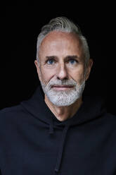 Mature man with beard against black background - FMKF07751