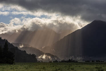 Neuseeland, Region Westküste, Sonnenlicht dringt durch die über den Südalpen schwebenden Wolken - RUEF03844