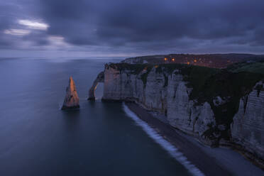 Frankreich, Normandie, Etretat, Klippen von Falaise dAval und Aiguille dEtretat in der bewölkten Abenddämmerung - RUEF03855