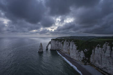 Frankreich, Normandie, Etretat, Klippen von Falaise dAval und Aiguille dEtretat in der bewölkten Abenddämmerung - RUEF03857