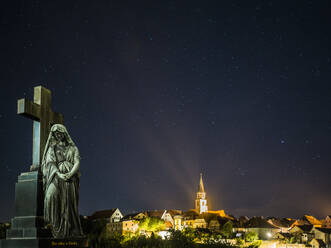 Germany, Bavaria, Nabburg, Tombstone at night with illuminated town in background - HUSF00315