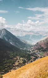 Malerische Landschaft der Pyrenäen mit felsigen Gipfeln in der Nähe eines kleinen Dorfes bei bewölktem blauem Himmel im Val d Aran - ADSF39896