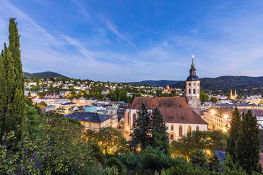 Deutschland, Baden-Württemberg, Baden-Baden, Stadt im Schwarzwald in der Abenddämmerung mit Kirche im Vordergund - WDF07066