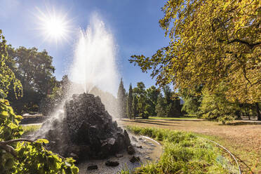 Deutschland, Baden-Württemberg, Baden-Baden, Sonne über plätscherndem Springbrunnen im Park Lichtentaler Allee - WDF07075