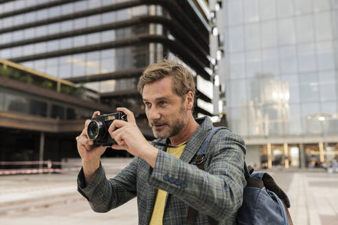 Mann macht Fotos mit Kamera in der Stadt - JCCMF07745