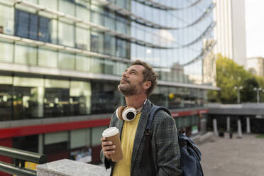 Man with disposable coffee cup in city - JCCMF07750