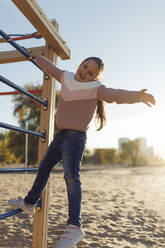 Happy girl with arms outstretched enjoying at beach - JBUF00079