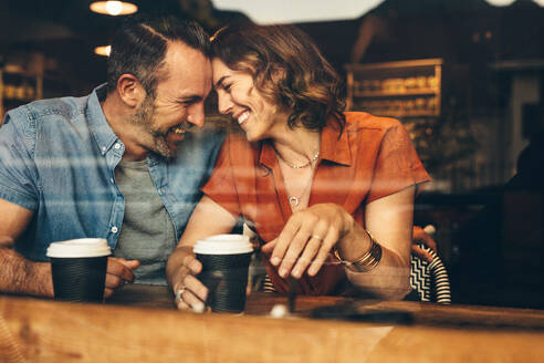 Schönes verliebtes Pärchen bei einem Kaffee-Date. Verliebtes Paar sitzt im Café, berührt sich und lächelt. - JLPSF12448