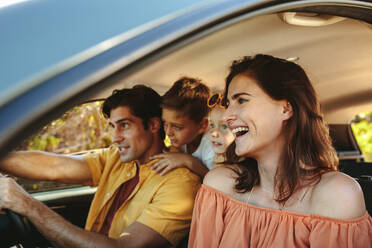 Father driving car with family. Happy family with two children driving in a car and having fun. - JLPSF12488