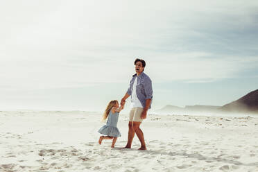 Vater und Tochter haben Spaß beim Spielen am Strand. Mädchen hat eine tolle Zeit mit ihrem Vater im Strandurlaub. - JLPSF12504