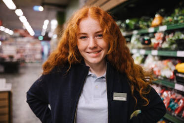 Porträt einer jungen Supermarktangestellten, die einen Ferienjob in einem Lebensmittelgeschäft ausübt. - JLPSF12546