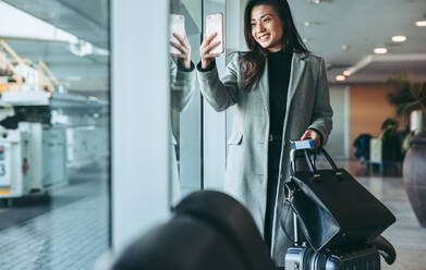 Weibliche Reisende in der Flughafen-Lounge, die Selfie. Frau Passagier im Wartebereich für den Flug am internationalen Flughafen. - JLPSF12635