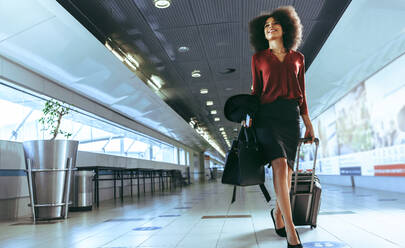 Businesswoman moving to terminal gate for check in boarding with luggage at the airport. Female passenger going on business trip. - JLPSF12651