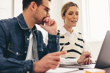 Two businesspeople having a discussion with their clients during an online meeting. Modern businesspeople having a video conference in a creative office. - JLPSF12916