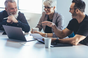 Smiling business people discussing in meeting room. Happy and positive business team meeting in conference room. - JLPSF13045