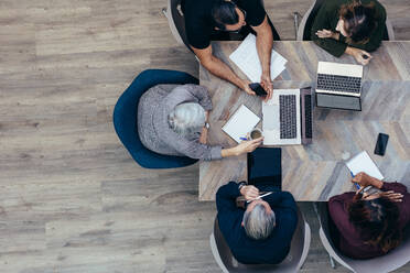 Top view od senior businesswoman discussing with her coworkers. Business team meeting in office. - JLPSF13054