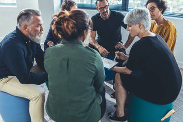 Multi-ethnic group of people sitting together having a meeting. Business people having a group discussion on new working strategy. - JLPSF13126