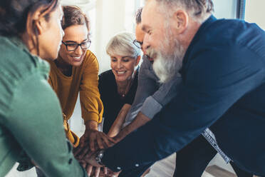 Successful business people hands stacked together. Business team showing unity. - JLPSF13142