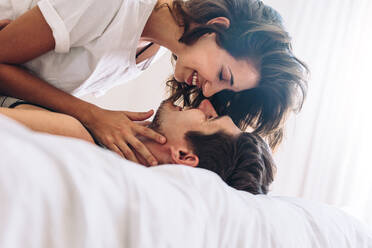 Loving young couple together in bed. Romantic couple about to kiss. - JLPSF13350