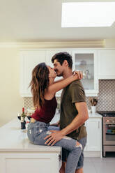 Verliebtes junges Paar in der Küche zu Hause. Verliebtes Paar küsst sich zu Hause. - JLPSF13377