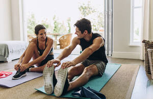 Paar beim gemeinsamen Training: Mann und Frau in Sportkleidung beim Workout zu Hause. - JLPSF13383