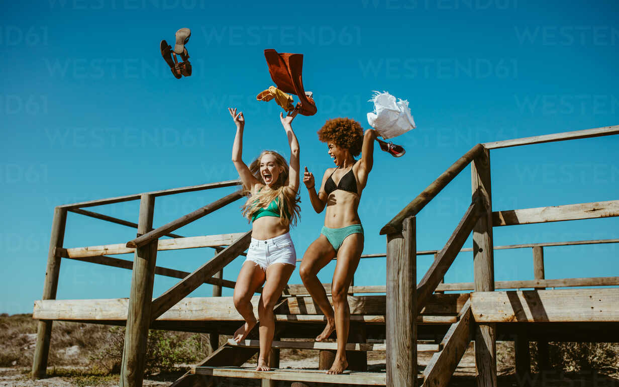 https://us.images.westend61.de/0001739705pw/woman-friends-taking-off-their-clothes-and-throwing-while-running-towards-the-ocean-excited-women-going-for-swimming-in-the-sea-on-a-summer-day-JLPSF13411.jpg