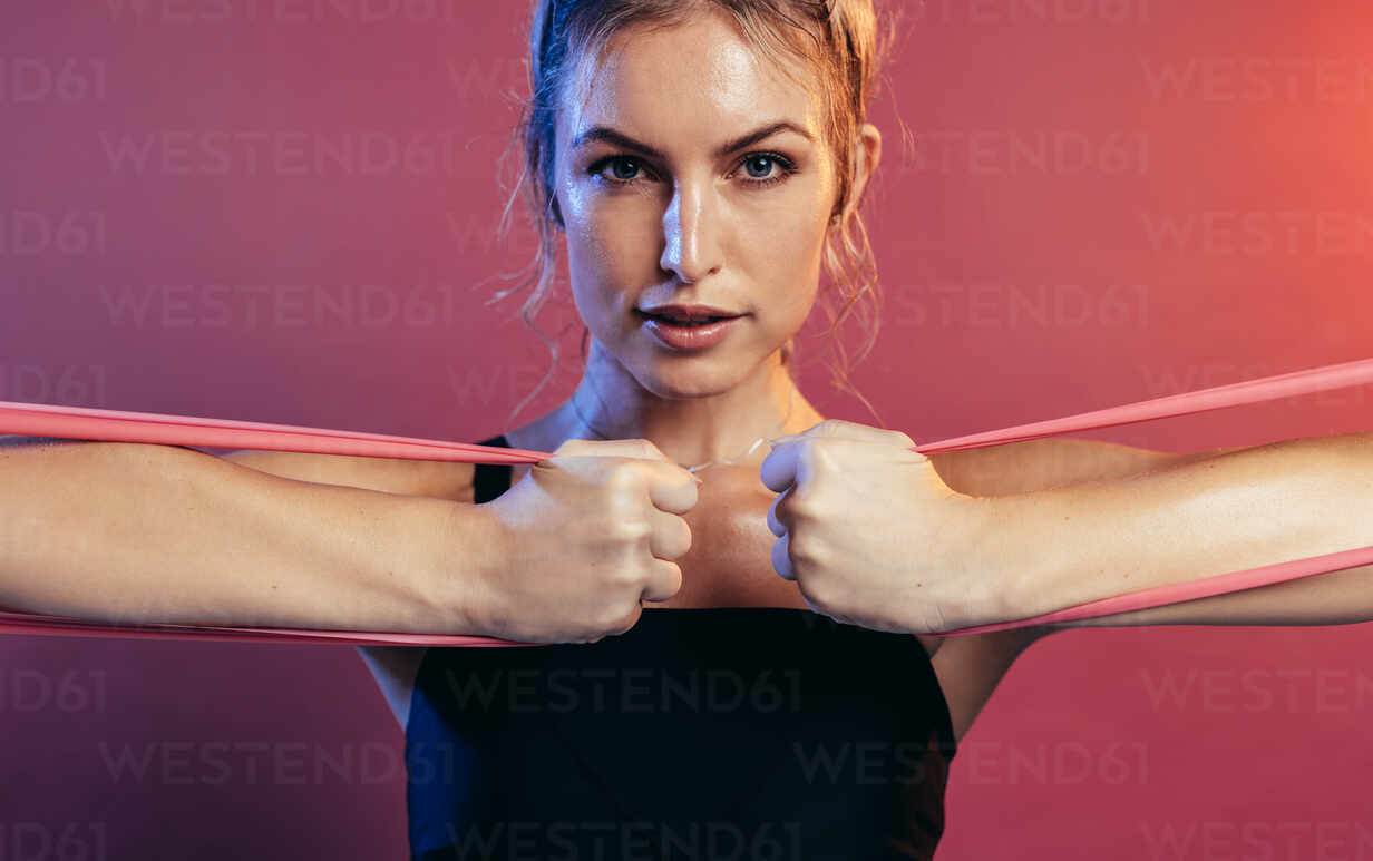 Portrait of Confident Sportswoman Stretching Elastic Band with