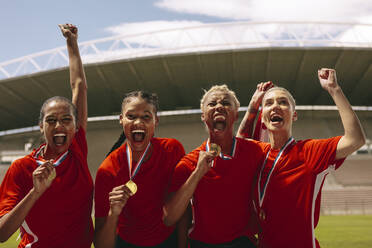 Frauenfußballspielerinnen mit Medaillen, die nach dem Gewinn der Meisterschaft vor Freude jubeln. Frauenfußballmannschaft, die im Stadion den Sieg feiert. - JLPSF13738