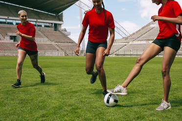 Gruppe von Frauen spielen Fußball auf dem Feld läuft für den Ball. Weibliche Fußballspieler laufen auf dem Feld für den Besitz des Balles. - JLPSF13743