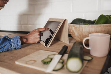 Hands of woman using tablet PC at kitchen counter - EBBF06643