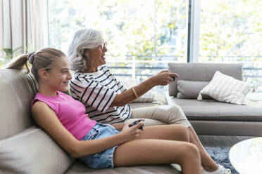 Großmutter und Enkelin verbringen ihre Freizeit mit einem Videospiel auf dem Sofa zu Hause - JSRF02237