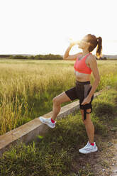 Woman drinking water on footpath - EGHF00599