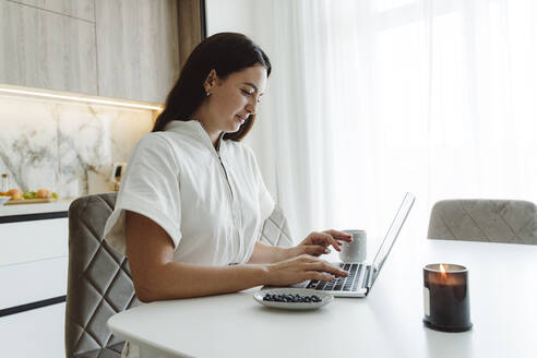 Geschäftsfrau mit Laptop am Tisch - OSF01091