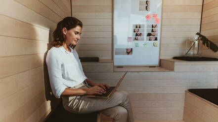 Businesswoman sitting in creative office working on laptop. Female executive using laptop computer in office. - JLPSF13826