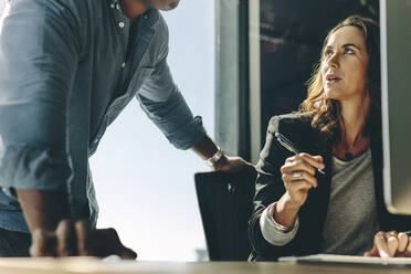 Zwei Geschäftspartner besprechen die Arbeit im Büro. Geschäftsleute arbeiten zusammen am Schreibtisch. - JLPSF13848