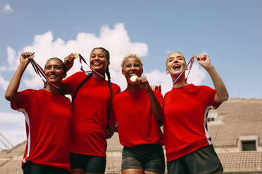 Fußballspielerinnen mit Medaillen nach dem Gewinn der Meisterschaft. Frauenfußballmannschaft feiert den Sieg im Stadion. - JLPSF13923