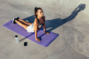 Frau in Sportkleidung übt Yoga im Freien. Sportliches Mädchen beim morgendlichen Yoga-Workout. - JLPSF13971