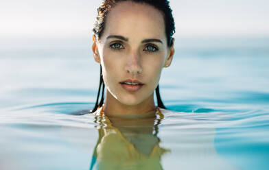 Gesicht einer jungen Frau auf der Wasseroberfläche eines Swimmingpools. Gesicht einer schönen Frau im Wasser. - JLPSF14026