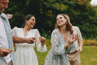 Cheerful young people dancing at the park. Group of men and women enjoying on picnic outdoors. - JLPSF14066