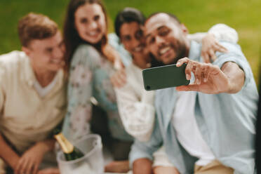 Freunde nehmen Selbstporträt mit einem Handy im Park. Gruppe von jungen Menschen auf Picknick ein Selfie zu nehmen. - JLPSF14183