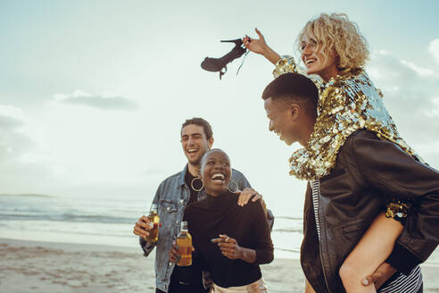 Eine Gruppe multiethnischer Freunde, die ihren Urlaub am Strand genießen. Zwei fröhliche Paare im Sommerurlaub. - JLPSF14267