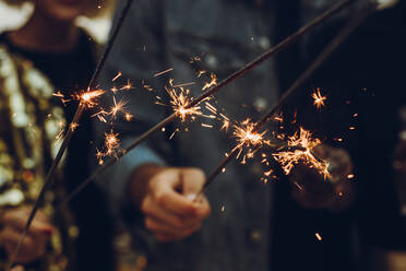 Nahaufnahme von Freunden mit Wunderkerzen in der Hand. Gruppe von Freunden, die gemeinsam Silvester feiern. - JLPSF14281