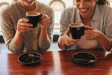 Nahaufnahme von zwei Frauen, die an einem Kaffeetisch sitzen und Kaffee trinken. Frauen, die in einem Café Kaffee trinken. - JLPSF14437