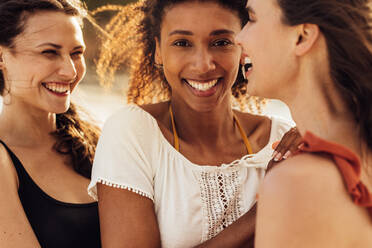 Nahaufnahme von drei Freundinnen, die im Freien stehen. Ausschnitt von multiethnischen Freundinnen, die zusammen stehen und lachen. - JLPSF14451